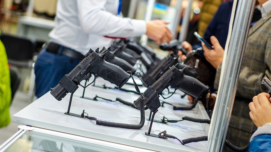 Customers look at guns on display
